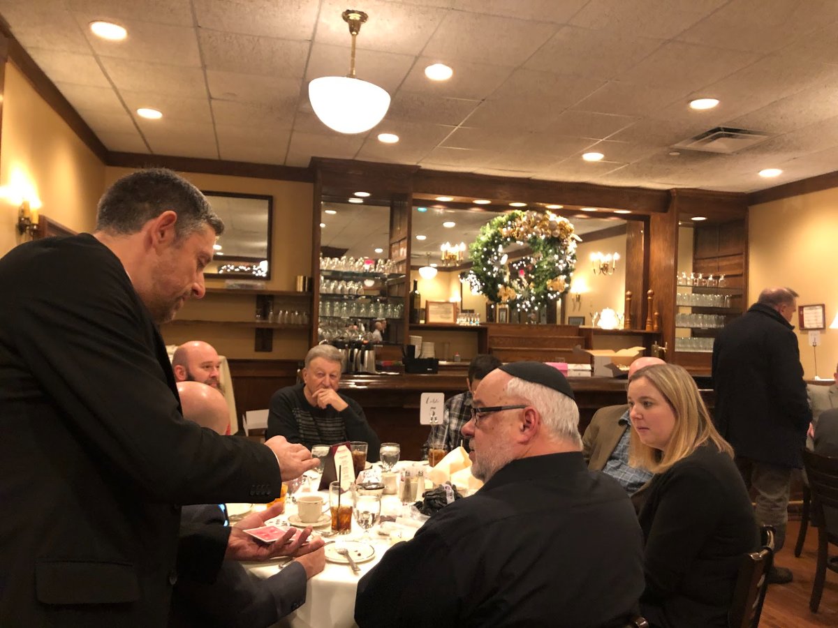 Corporate event magician and mentalist performing close-up magic for guests at a company party in Chicago’s western suburbs