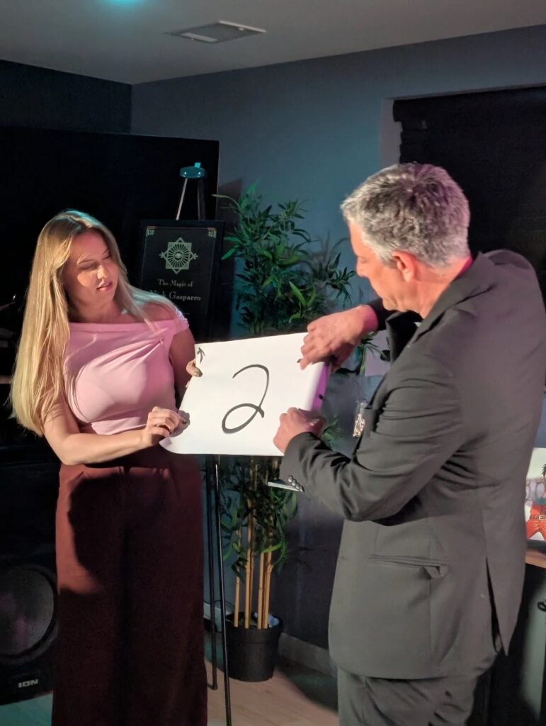 Nick Gasparro revealing a mentalism prediction with a guest at a wedding reception near Chicago