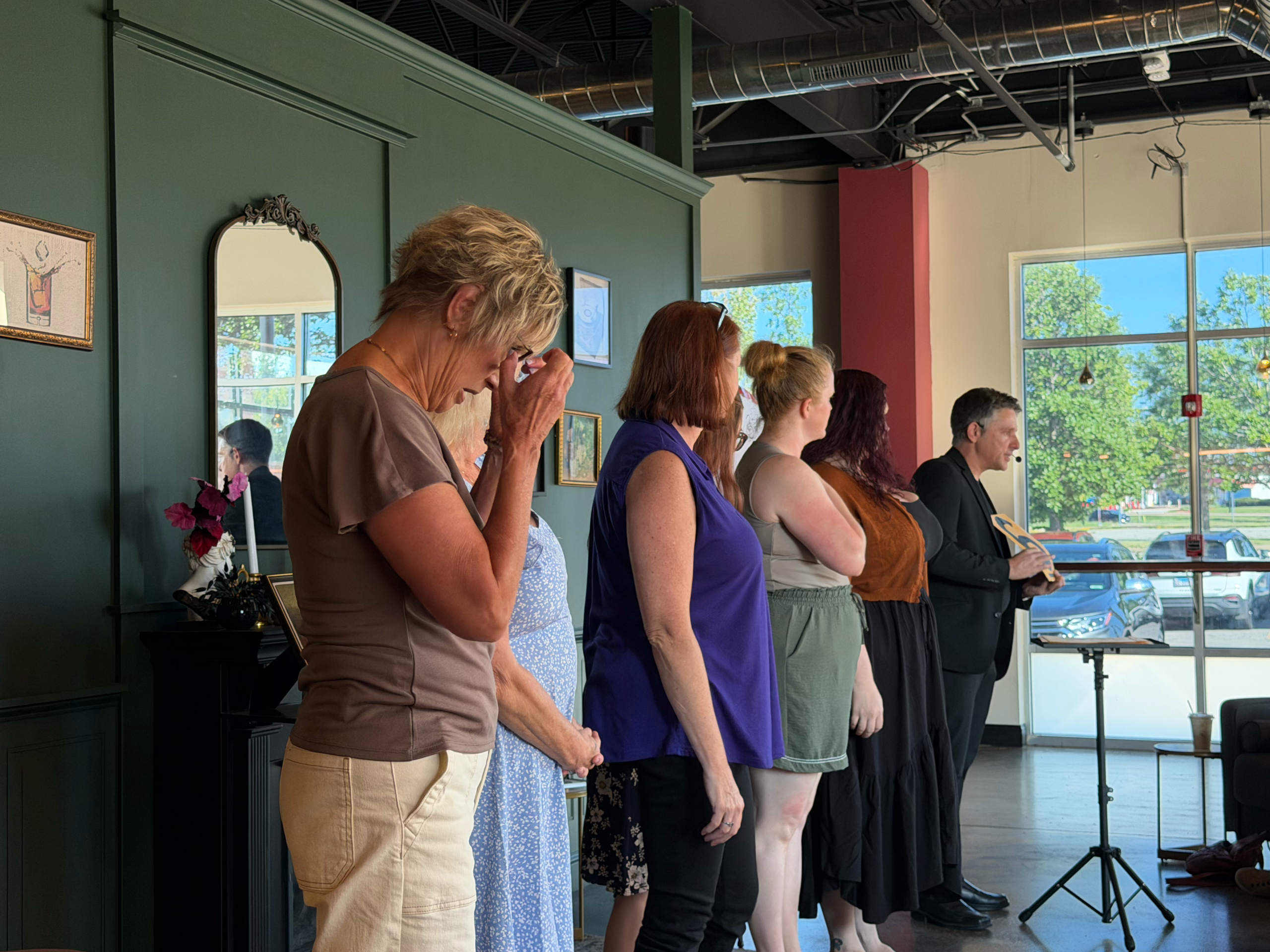 Adult guest reacting in amazement during a close-up magic and mentalism performance at a birthday party
