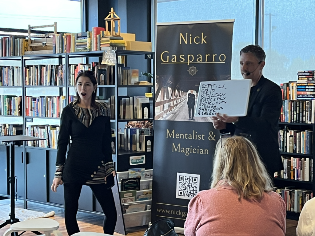 A volunteer's jaw drops as mentalist Nick Gasparro reveals his whiteboard mid-performance