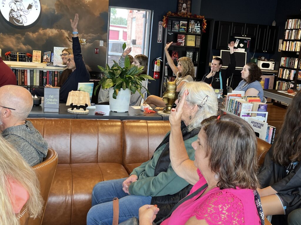 Guests on a leather couch raise their hands to take part in an interactive mind-reading show