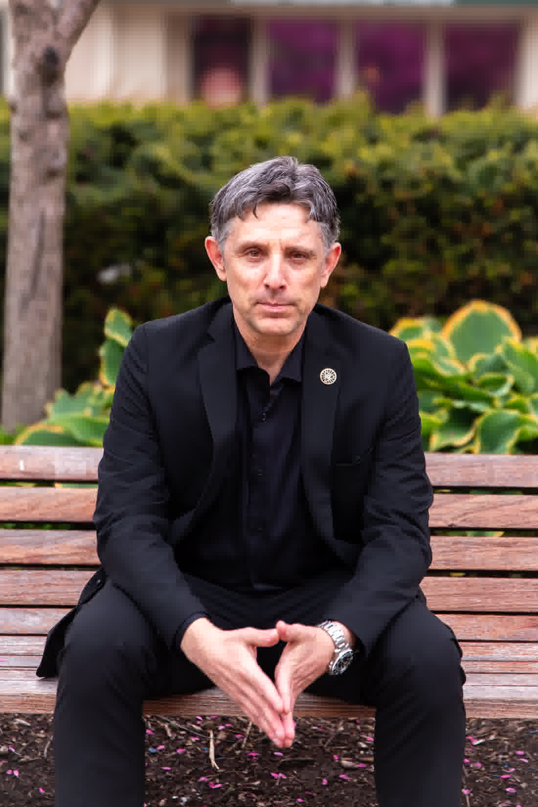 Nick Gasparro, magician and mentalist serving Frankfort, IL, seated on a bench outdoors