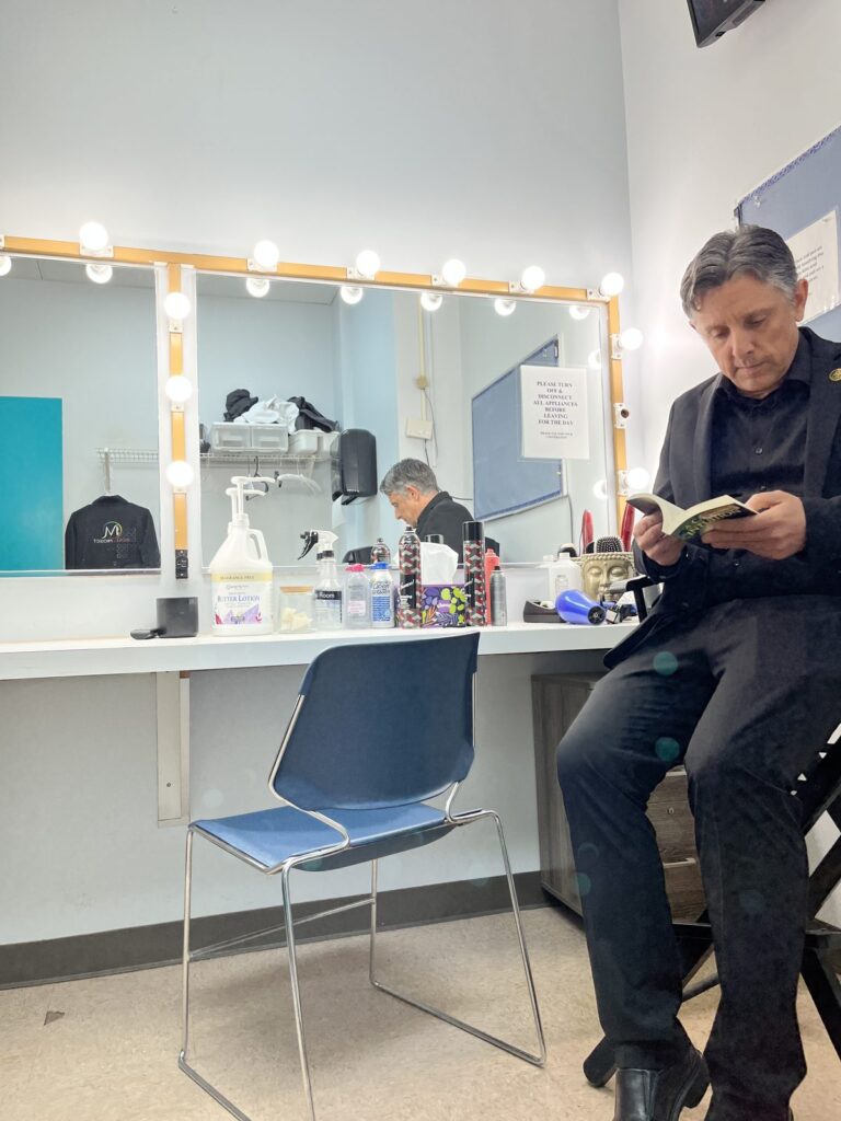 Mentalist Nick Gasparro reading a book in the WGN-TV dressing room before his segment
