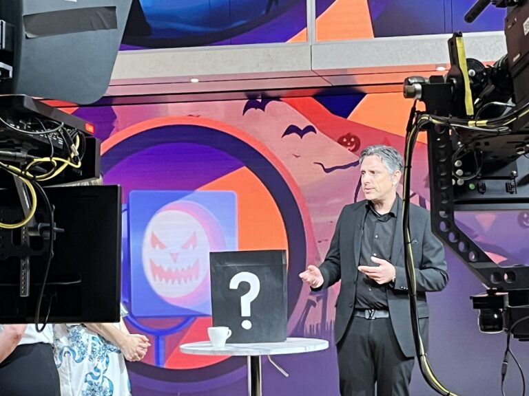 Mentalist Nick Gasparro beside a prediction box on the WGN Spotlight Chicago set